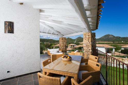 eine Terrasse mit einem Tisch und Stühlen auf dem Balkon in der Unterkunft Villas Resort Wellness & SPA in Castiadas