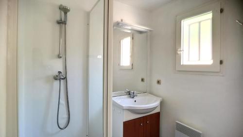 スーストンにあるS-Pinède 01-Soustons Villa duplex 2 chambres dans résidence familiale avec piscineの洗面台とシャワー付きの白いバスルーム