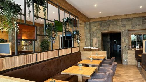 a restaurant with two wooden tables and chairs at Alpenstadthotels in Bad Reichenhall