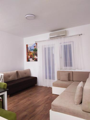 ein Wohnzimmer mit einem Sofa und einem Tisch in der Unterkunft Studio Petlja - Igalo in Herceg-Novi