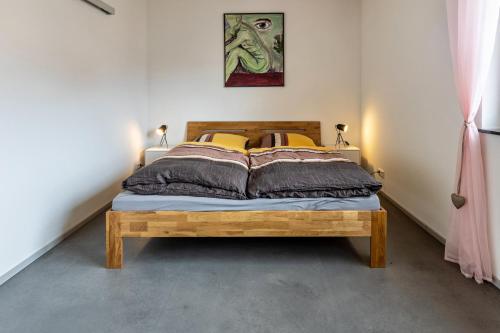 ein Schlafzimmer mit einem Holzbett in einem Zimmer in der Unterkunft Apfelkiste in Meßstetten