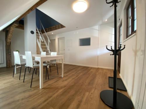 a dining room with a table and chairs and a staircase at Business Apartment ZIMMERzuVERMIETEN in Wangen an der Aare in Wangen an der Aare