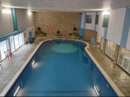duży basen w dużym budynku w obiekcie Hillside Chalet w mieście Kilkhampton