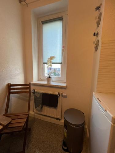 a bathroom with a window and a trash can at Sweet Home cozy Dresden Apartment three in Dresden