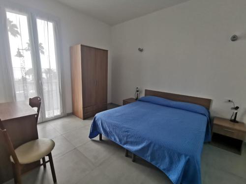 una camera con letto, tavolo e sedia di Affittacamere Montecarlo a Laigueglia
