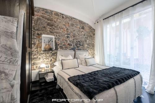 a bedroom with a large bed and a brick wall at Portofino Luxury Front Marina by PortofinoVip in Portofino