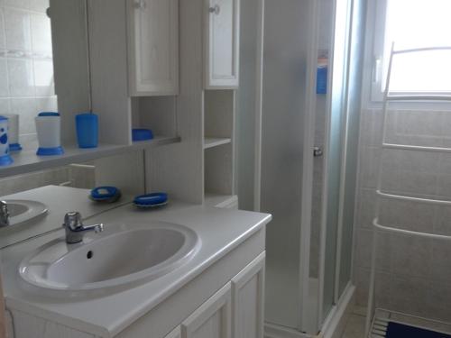 een witte badkamer met een wastafel en een douche bij Maison Grues, 3 pièces, 5 personnes - FR-1-476-31 in Grues