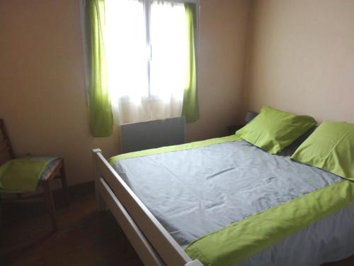 Un dormitorio con una cama con sábanas verdes y una ventana en Maison L'Aiguillon-sur-Mer, 3 pièces, 4 personnes - FR-1-476-11, en LʼAiguillon-sur-Mer