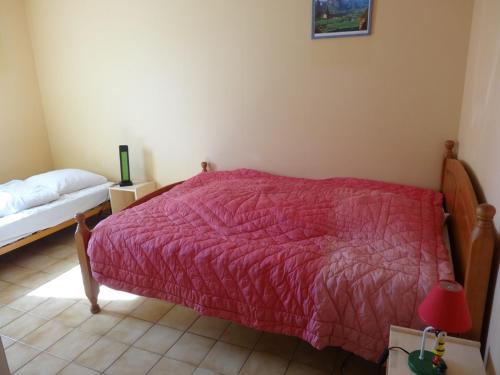 une chambre avec un lit avec une couverture rouge dans l'établissement Charmante maison 5 pers, proche plage et centre, avec jardin, BBQ et Wi-Fi, L'Aiguillon-sur-Mer - FR-1-476-42, à LʼAiguillon-sur-Mer