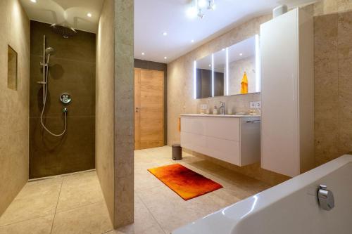 bagno con vasca, lavandino e doccia di Ferien am Sonnberg a Unken