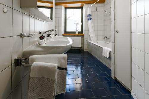een badkamer met een wastafel, een toilet en een bad bij Casa Bernina in Poschiavo