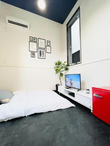 a bedroom with a bed and a tv and a window at Alo BnB 4 - Near KABUKICHO, SHINJUKU, SHINOKUBO, SHIBUYA - Self check-in in Tokyo