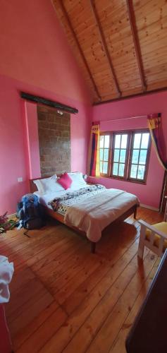 a bedroom with a large bed in a room with pink walls at Sincere Wilderness Home stay in Nuwara Eliya