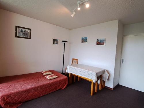 Un dormitorio con una cama y una mesa. en Appartement Pra-Loup, 2 pièces, 4 personnes - FR-1-165A-85 en Uvernet