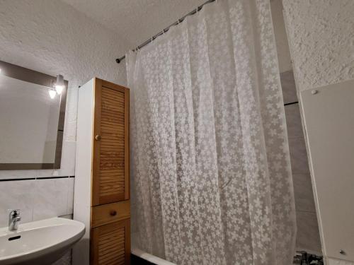 y baño con cortina de ducha y lavamanos. en Appartement Pra-Loup, 2 pièces, 4 personnes - FR-1-165A-85 en Uvernet