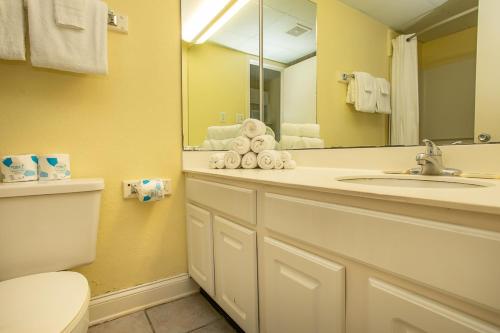uma casa de banho com um lavatório, um WC e um espelho. em Sea Mist 51001 em Myrtle Beach