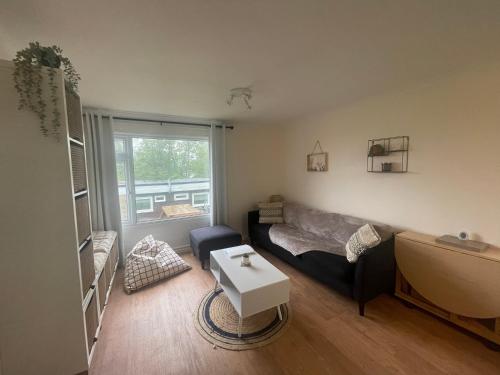 een woonkamer met een bank en een tafel bij 2 Bedroom Holiday Chalet near Bude in Kilkhampton