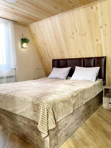Un dormitorio con una cama grande con techo de madera. en Wood Rest Tsaghkadzor, en Tsaghkadzor