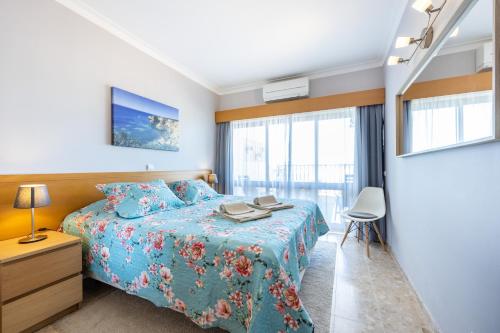 a bedroom with a bed with a blue bedspread at Clube Praia Mar Flat T1 in Portimão