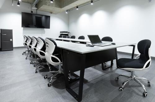 a conference room with a table with a laptop and chairs at Pangyo Business & Tourist Hotel KYND in Seongnam