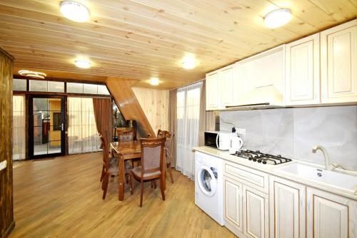 a kitchen with a stove top oven next to a table at Wood Rest Tsaghkadzor in Tsaghkadzor
