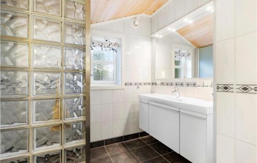 Baño blanco con lavabo y espejo en Cozy Home In Meisingset With Kitchen, 