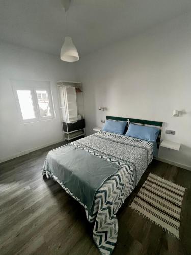 a bedroom with a large bed with blue pillows at Casa Rosaura in La Santa