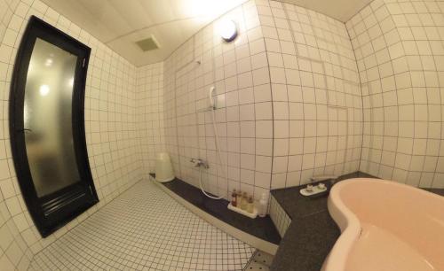 Hotel RR (Adult Only) في يوكايتشي: حمام من البلاط الأبيض مع حوض استحمام ومغسلة