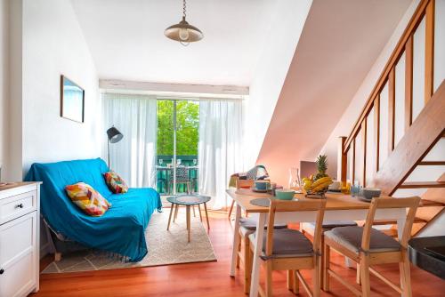 - un salon avec un canapé bleu et une table dans l'établissement Bananec- Appt à 300 mètres de la plage, à La Forêt-Fouesnant