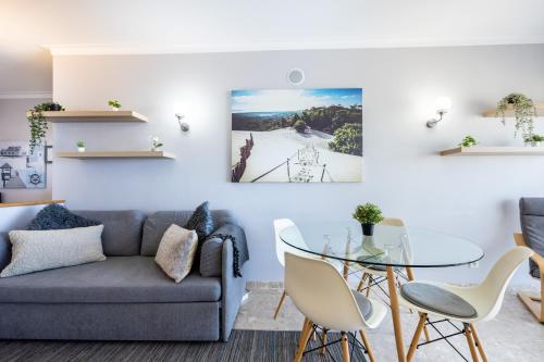 a living room with a couch and a glass table at Clube Praia Mar Flat T1 in Portimão