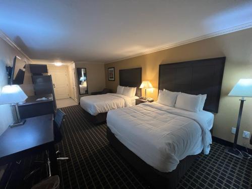 a hotel room with two beds and a desk at MainStay Suites Ozona I-10 in Ozona