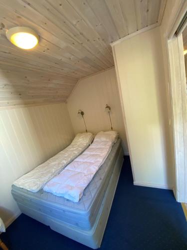 a bed in a small room with a ceiling at Bergland apartment 28 - close to the center of Kragerø in Kragerø