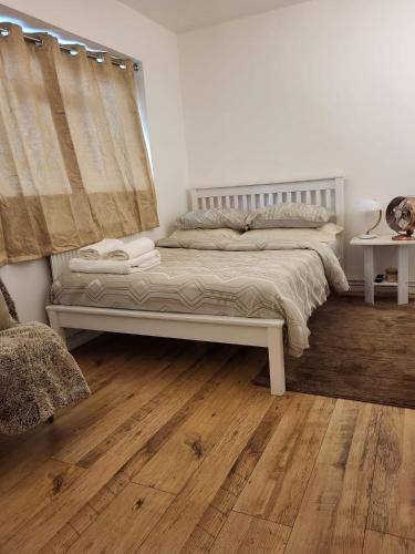 Schlafzimmer mit einem Bett und Holzboden in der Unterkunft Quality space in Havering atte Bower
