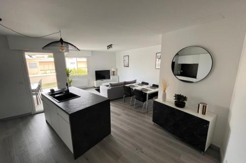 a living room with a kitchen and a living room with a mirror at Apartment hyper-center Biarritz with parking in Biarritz