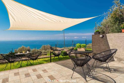 een patio met tafels en stoelen onder een luifel bij Affittacamere Niria, Terre Marine in Volastra
