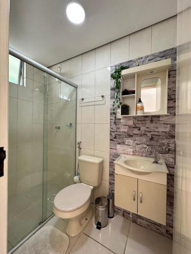 a bathroom with a toilet and a sink and a shower at Flat CasaSouza in Santa Maria