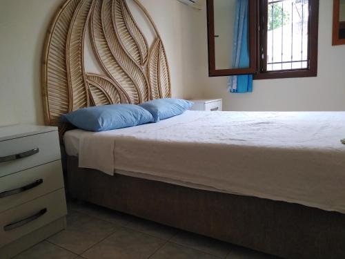 um quarto com uma cama e uma cabeceira em madeira em Villa Çalış em Fethiye
