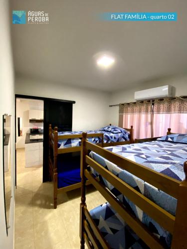 a bedroom with two bunk beds and a tv at Pousada Águas de Peroba Flats e Suites in Maragogi