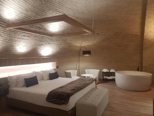 a bedroom with a large bed and a bath tub at Hotel Maria Cristina in Toledo