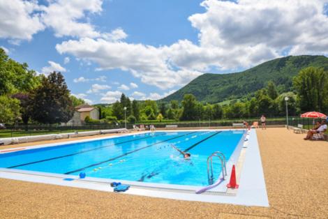 - une grande piscine avec des personnes à l'eau dans l'établissement Domaine Du Roc Nantais, à Nant