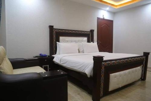 a bedroom with a bed and a chair and a couch at POOL & PARK RESORTS in Lahore