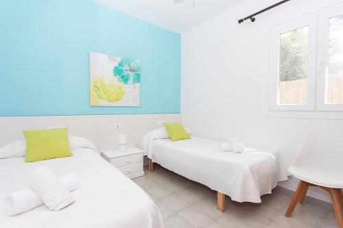 Un dormitorio con dos camas y una mesa. en Villa Albe by Sonne Villas, en Cala Galdana