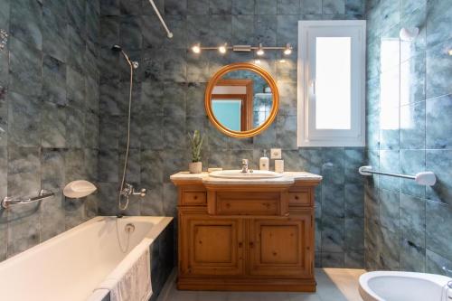 a bathroom with a tub and a sink and a mirror at Villa Albe by Sonne Villas in Cala Galdana