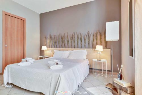een slaapkamer met een groot wit bed en handdoeken bij Affittacamere Niria, Terre Marine in Volastra