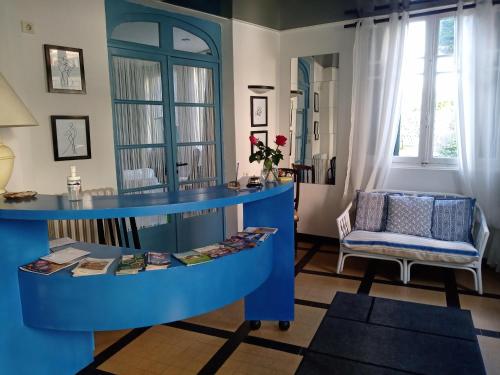 uma sala de estar com uma mesa azul e uma cadeira em Les Chenes Chambres D'hote em Châtel-Guyon