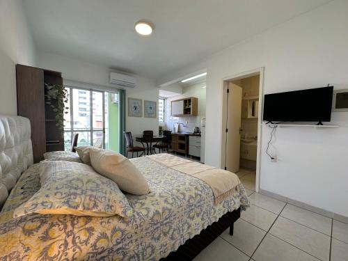 a bedroom with a bed and a flat screen tv at Flat CasaSouza in Santa Maria