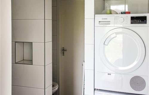 Una lavadora y secadora blancas en un baño blanco en Cozy Home In Ijhorst With Kitchen, en IJhorst