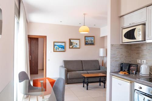 a kitchen and a living room with a couch at Aspa Holidays in Kos