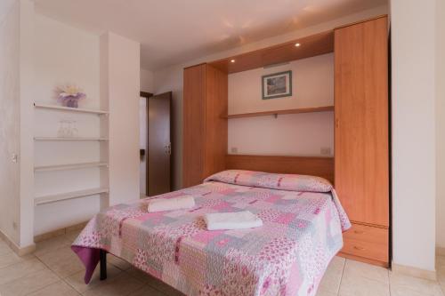 a bedroom with a bed with a pink blanket at Villino nel Bosco in Capoliveri
