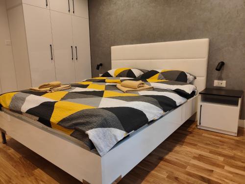 a bedroom with a bed with a yellow and black blanket at City Center Belgrade Dorćol Square in Belgrade
